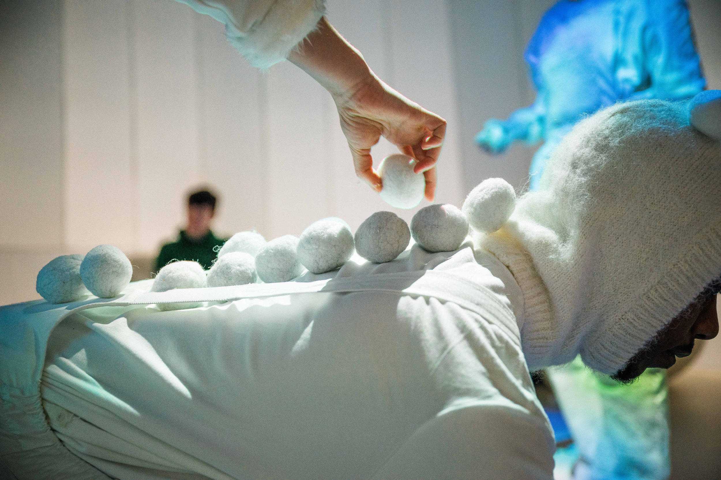 A hand explores a textured white sensory landscape with pale blue spheres in Brrr.